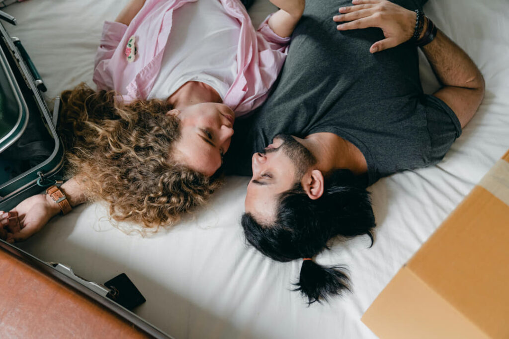 a couple cuddling on their bed