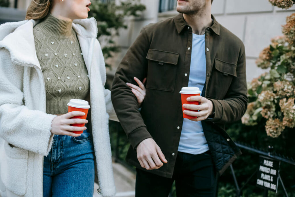 a couple walking with coffees