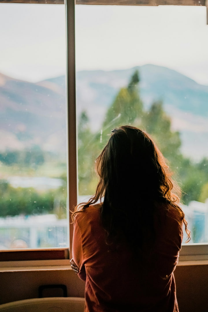 a lonely girl looking out the window