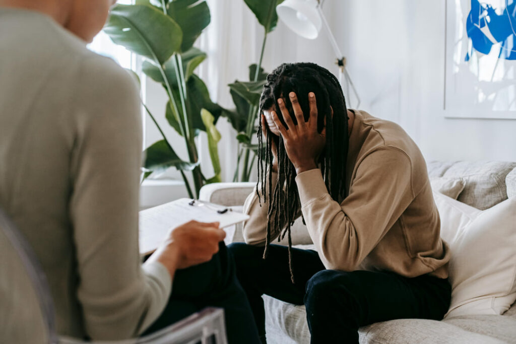 a man with his face in his hands struggling.