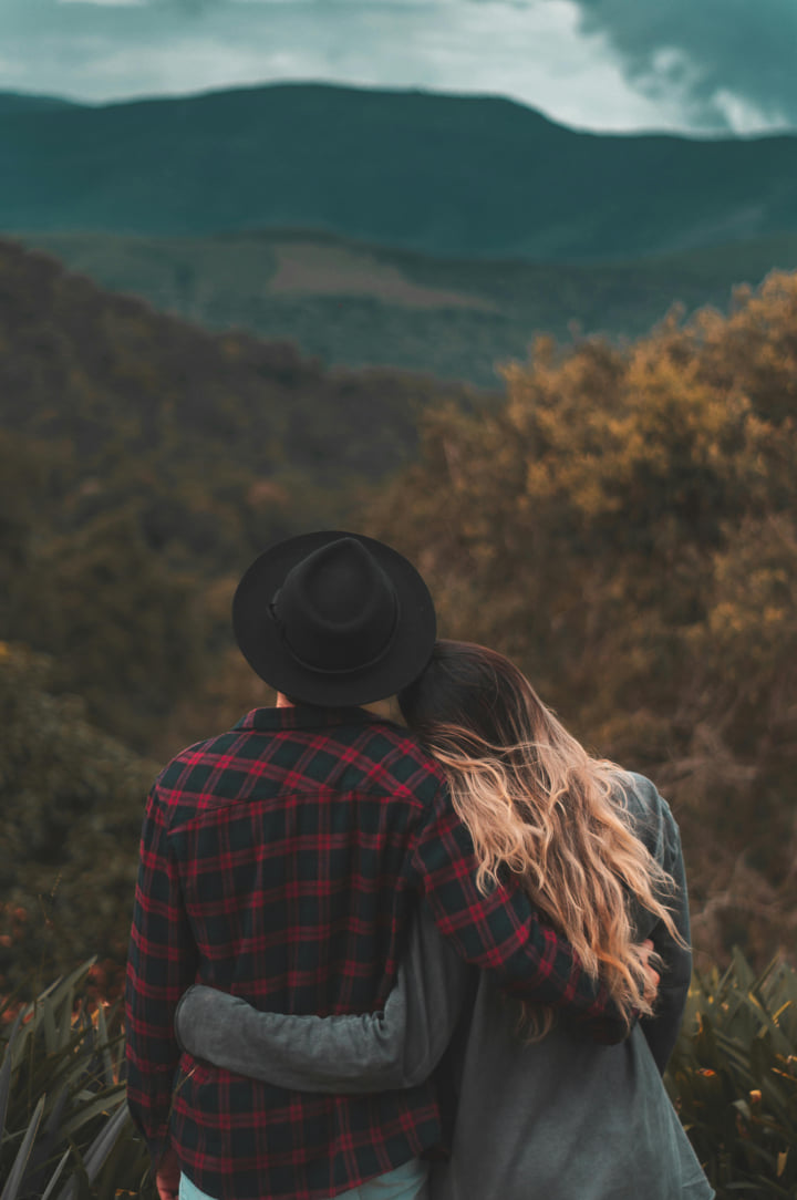 a couple looking at a view of mountains